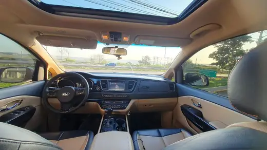 Interior de minivan com bancos de couro bege, painel e teto solar
