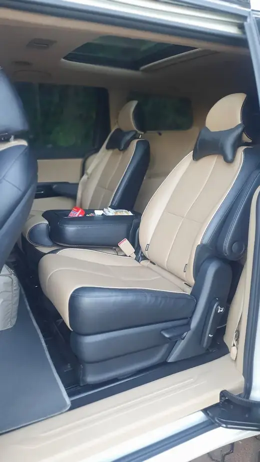 Poltronas individuais de couro bege na segunda fileira de uma minivan