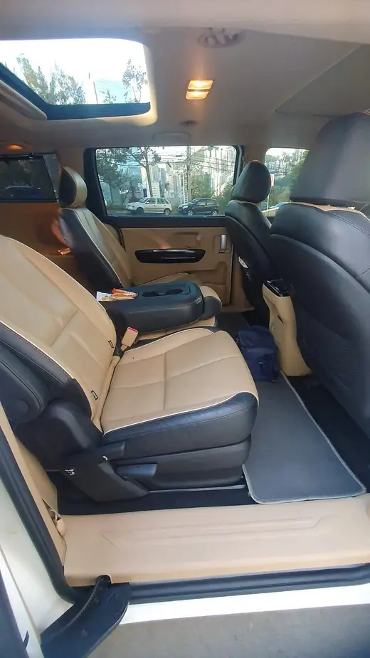 Segunda fileira de poltronas de couro bege em uma minivan