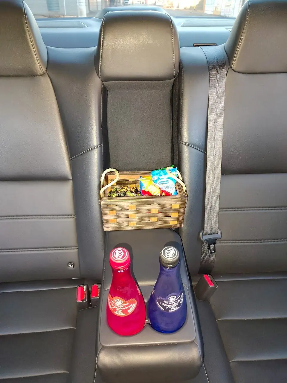 Kit de boas-vindas com águas e petiscos no banco traseiro de um sedan executivo