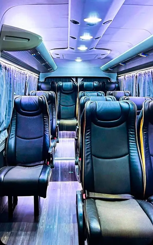 Corredor de van executiva com poltronas de couro preto e iluminação de LED no teto