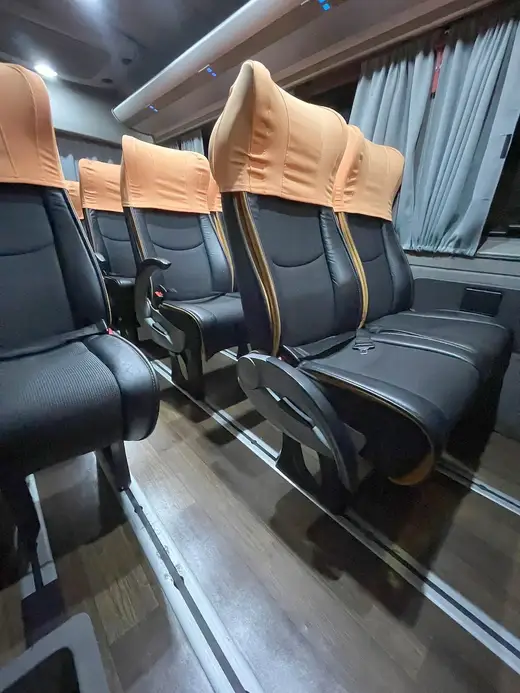 Poltronas de couro preto com encostos de cabeça caramelo no interior de uma van