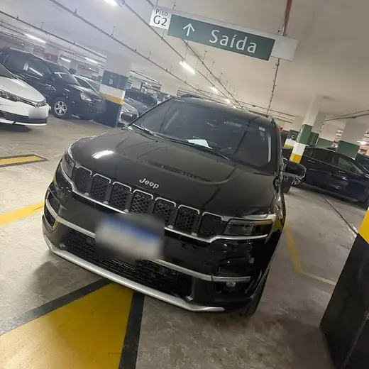 Jeep Commander preto, utilitário de 7 lugares, visto de frente em garagem