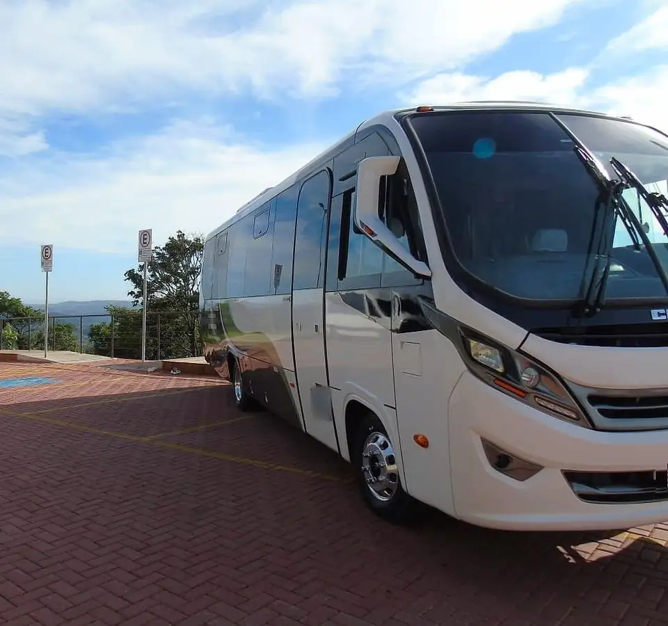 Micro-ônibus branco estacionado em um mirante com vista para as montanhas