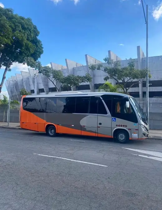 Micro-ônibus laranja e prata estacionado diante do Estádio Mineirão, em Belo Horizonte