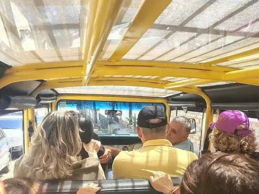 Passageiros em passeio de jardineira pelas ruas de Ouro Preto