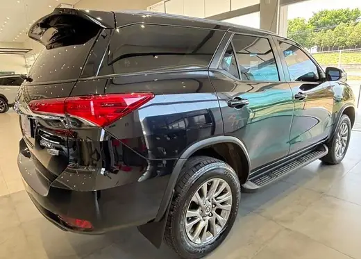 SUV Toyota SW4 preto visto de trás, em ambiente coberto